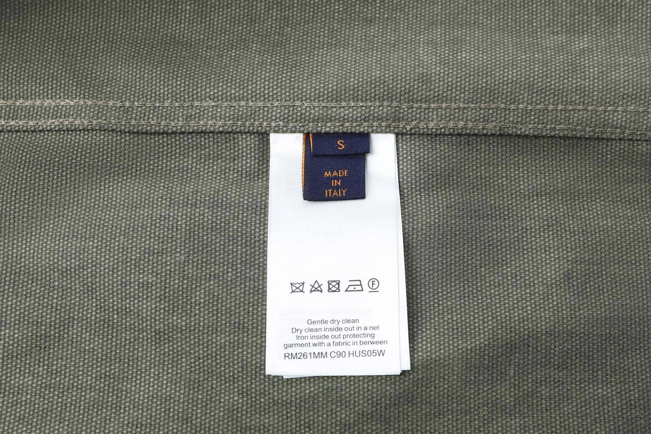 🅿️600 1v 25SS full-print green camouflage work jacket style shirt. The original purchase was 16,000 and developed. The fabric is made of custom-dyed 50-count plain double-ply pique cotton. Before positioning and cutting the fabric pieces, digital typesetting is used to lock the position of the full-print Monogram pattern to ensure that the pattern is continuous and without misalignment after splicing. The pattern alignment error between the body and the solid color splicing area is controlled within 0.5cm. The printing process uses digital direct injection technology: the pigment penetrates the fabric fibers with micron-sized particles, presenting a low-saturation vintage tone while maintaining the breathability of the fabric. The wear resistance of the printing layer reaches level 5 (friction test ≥ 200 times without falling off). The body is made of twill canvas blended fabric, and the splicing parts are reinforced with double-needle buried clip technology. The buttons are made of brass-plated matte paint, and the stitching is made of high-tenacity nylon thread with a tensile strength of 150N. The overall process takes into account both visual integrity and practical durability. The overall wiring is straight and delicate, the fabric is comfortable and soft, and the color is consistent without color difference. It can be matched with the same style to create a fashionable look and control various occasions. Customized accessories, complete with three standards, the same style for men and women. Size:S-M-L-XL
